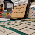 Tisch mit Informationsmaterial zu Datenschutz und IT-Sicherheit